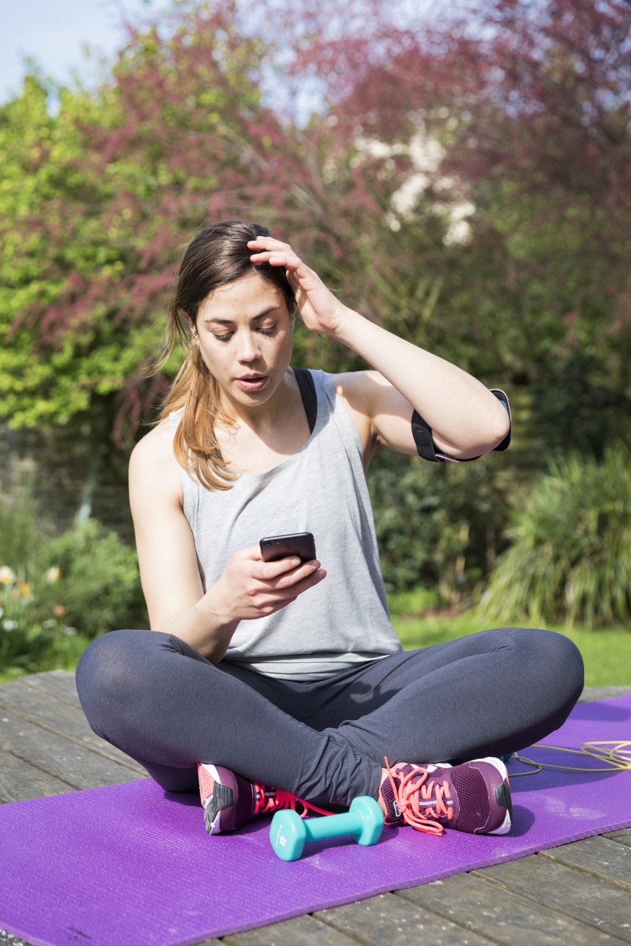 Jeune femme diabétique regardant ses mesures de glycémie après une séance de sport.
